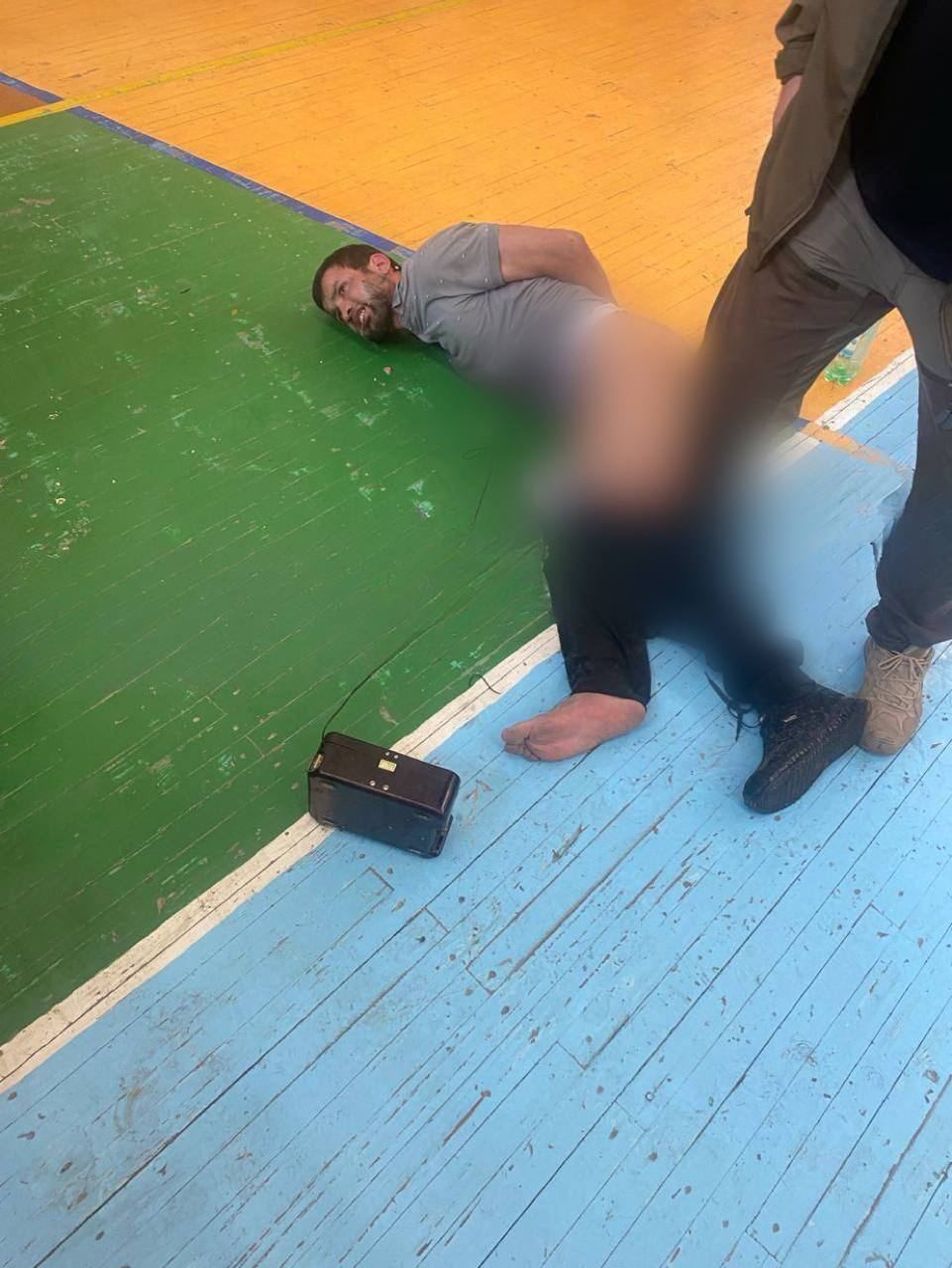 Появилось фото, где один из террористов лежит на полу, к нему подключены провода